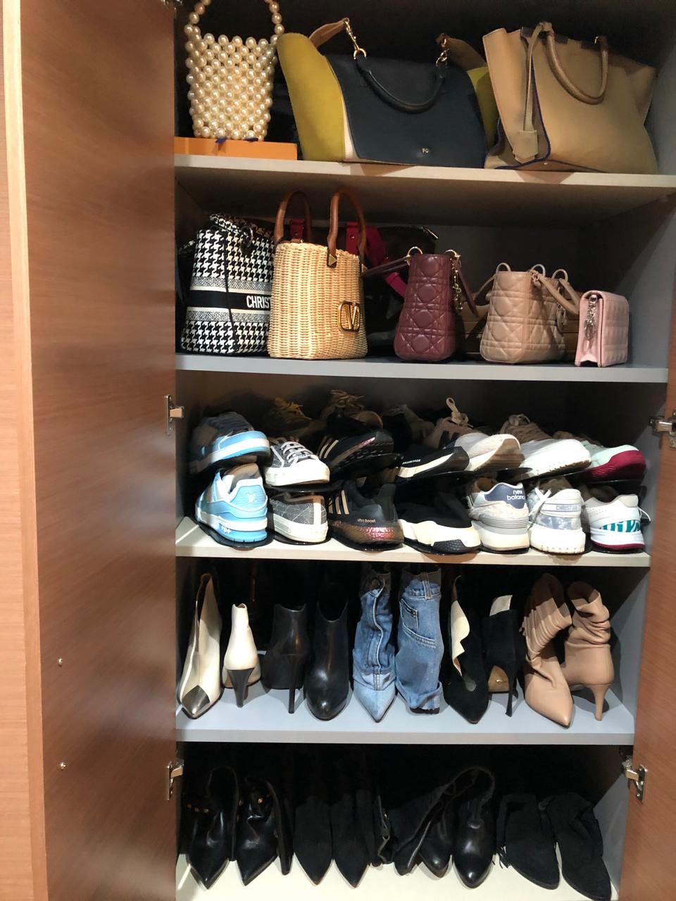 Sacs et souliers de créateurs rangés dans un dressing